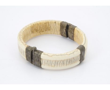 A late 19th century African ivory and silver mounted bangle  