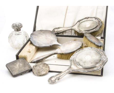 An Art Deco period cased three piece silver dressing table set, AF, together with a cut glass and silver scent bottle, a silv