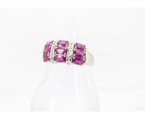 A modern 14ct white gold and ruby dress ring, the tablet set with nine oval synthetic rubies, 4.5g and size N 
