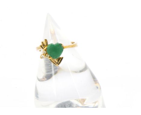 A gold and emerald ring, high carat mount with heart shaped green stone in retro style tablet set with three small brilliant 