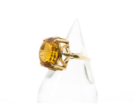 A 1960s yellow metal and single stone dress ring, the mount marked 18k, with large orange stone, chipped to underside, 5.8g a