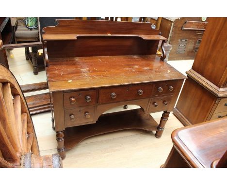 A mid Victorian mahogany dressing table, fitted with an upper shelf section, four short drawers and a long central drawer, ra