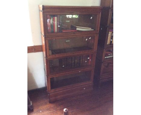 An Early 20th Century Oak Stackable four tier Globe Wernicke Bookcase fitted raising glass inlaid doors on each shelf.