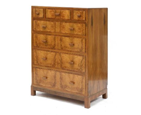 A walnut crossbanded chest of drawers,by Heal and Son, with an arrangement of three short and four graduated drawers, ivorine