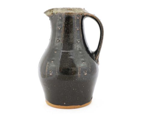 *Jim Malone (b.1946),a stoneware jug with a black tenmoku glaze and combed vertical lines and incised details, impressed with