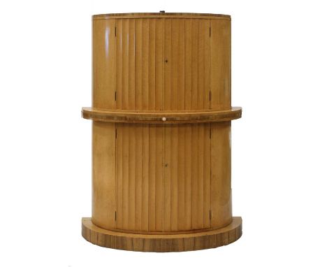 An Art Deco walnut and bird's-eye maple cocktail cabinet,in two parts, of demilune form with fluted cupboards, the top openin