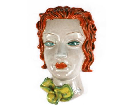 A Goldscheider pottery wall mask, No. 6911, modelled as a lady with orange flowing hair and turquoise eyes, orange lips with 