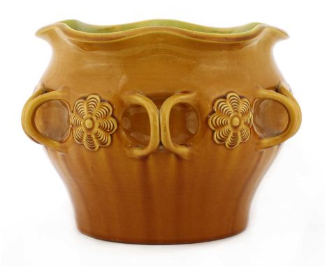 A Linthorpe Pottery jardinière,designed by Christopher Dresser (1834-1904), decorated with a yellow glaze to the outside and 