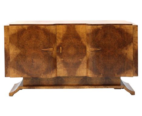 An Art Deco burr walnut sideboard,designed by Salaman Hille for S Hille Co. Ltd., London, of serpentine form, with three cupb