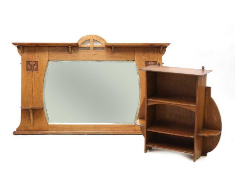 An Arts and Craft oak wall mirror,with a pierced arch top with a flat cornice, carved panels and shelves flanking the cushion