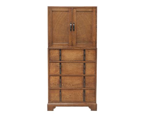 A Gordon Russell oak two-part cabinet and chest,  design No. X113, the panelled cupboard with radiating panelling, opening to