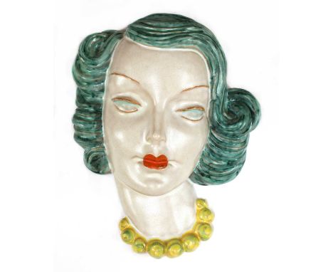 A Goldscheider pottery wall mask, No. 7950, modelled as a lady with flowing turquoise hair and eyes, orange lips and with a y