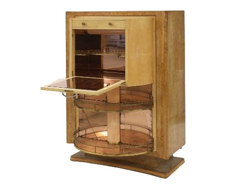 An Art Deco maple cocktail cabinet,with a hinged revolving front, revealing rose-tinted glass and mirror-clad shelves with ra