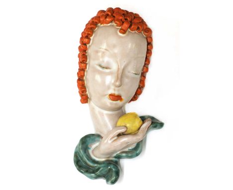 A small Goldscheider pottery wall mask, No. 6774, modelled as a lady holding an apple, her hair in orange, her robe in turquo