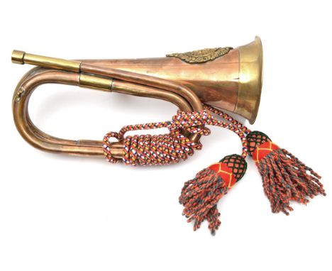 A copper and brass bugle, applied A & SH badge, coloured cords and tassels, and a small brass trumpet, 20”, both with mouthpi