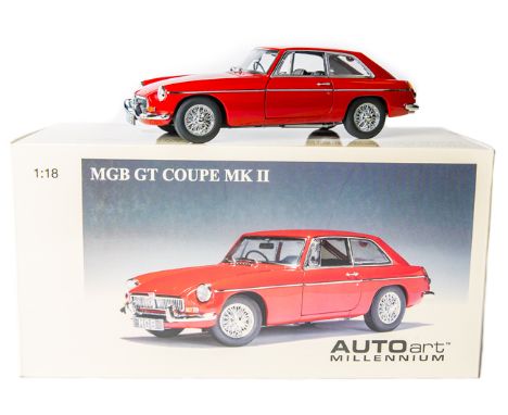 A 1:18 scale Autoart Millennium series MGB GT MK11. In red with black interior, fitted with ‘wire’ wheels, opening bonnet, do