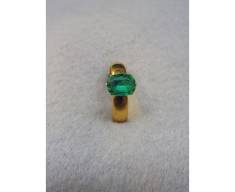 A 22ct gold ring set with a green stone.