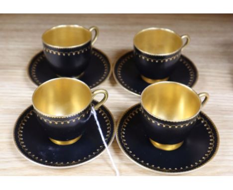 A set of four miniature Royal Worcester cups and saucers, in black and gilt design