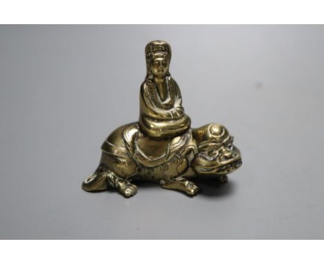 A small 18th century Chinese bronze group of Guanyin seated on a recumbent mythical beast, height 6cm