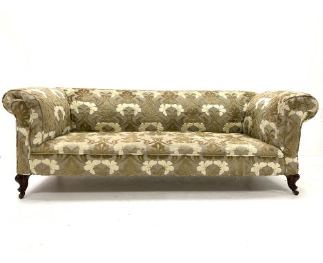 Late Victorian drop arm chesterfield sofa upholstered in textured floral fabric, raised on walnut leaf carved cabriole front 