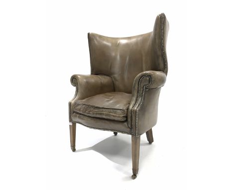 Georgian design barrel back wing armchair, upholstered in studded tan leather, with squab cushion, raised on square tapered s