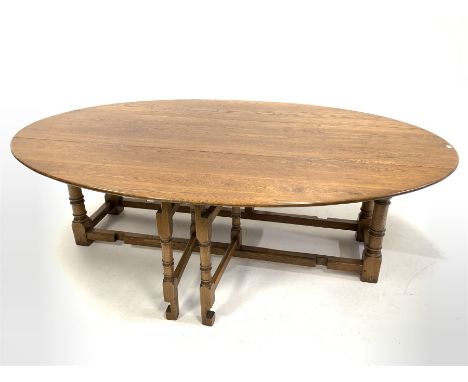 17th century style drop leaf wake dining table, the oval top raised on ring turned and block supports, each leaf having a dou