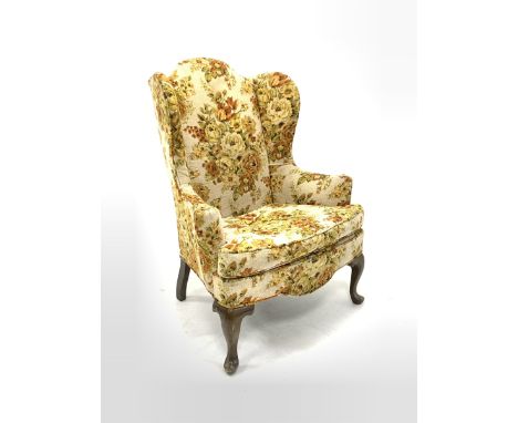 20th century wing back armchair, upholstered in floral fabric with squab cushion, raised on cabriole front supports  - Condit