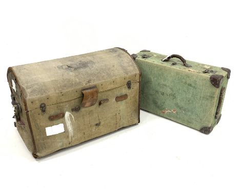 Early 20th century canvas covered dome top travelling trunk, with handle to each end and with old paper labels, interior bari