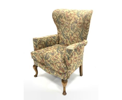 20th century wing back armchair, with swept arms, squab cushion upholstered in scrolled floral fabric, raised on cabriole fro