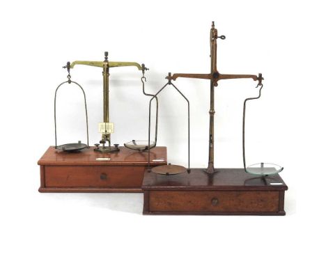 A set of early 20th century brass balance scales, 29cm wide, with weights, together with another pair, similar (2). Note: a n