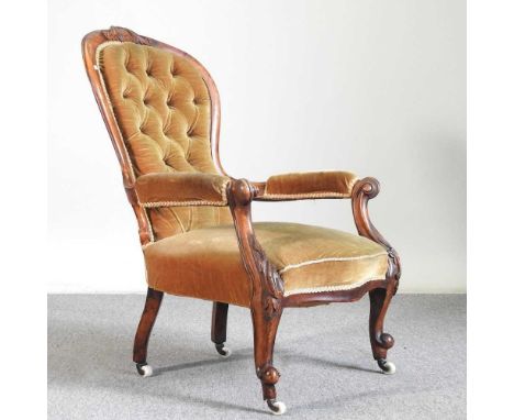 A Victorian gold upholstered button back armchair, on cabriole legs