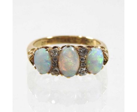 An 18 carat gold ring, set with three graduated oval opals, separated by diamonds, 5g, size L/M, boxed