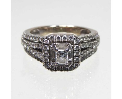 An 18 carat white gold diamond cluster ring, with diamond set shoulders, approximately 1.0 carat gross, 5.2g, size I