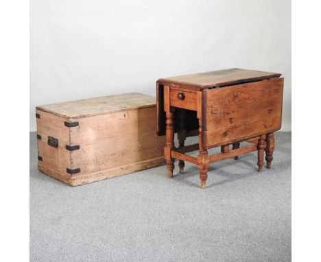 An antique metal bound pine trunk, with a hinged lid, 74cm wide, together with a pine pembroke table (2)74w x 50d x 74h cm