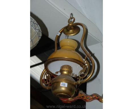A brass hanging Lantern style Light fitting with amber glass shade