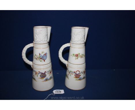 A pair of Royal Worcester Jugs, white ground, decorated with Butterflies, flowers and urns, the upper portion with flower bra