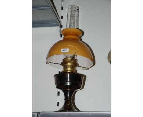 An Aladdin paraffin Lamp with amber shade and chimney