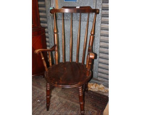 A Welsh style Carver Chair, stick back in turned supports, circular seat, scroll end arms and standing on turned legs and str