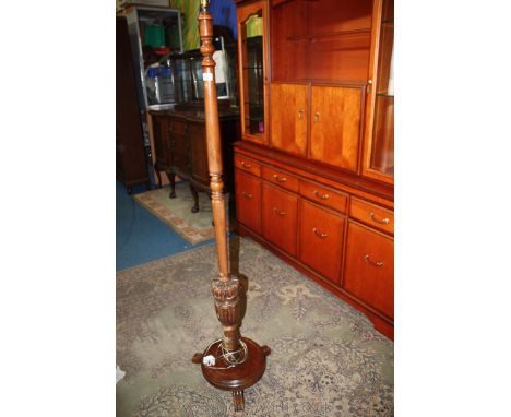 An Oak Standard Lamp, having turned column with heavily carved baluster lower section, standing on circular platform base wit