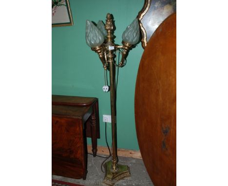 A brass triple Standard Lamp with three glass torch shaped shades.