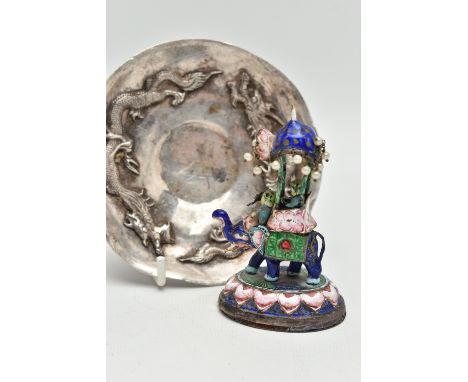 A WHITE METAL DISH AND AN ENAMEL FIGURINE, circular dish decorated with two oriental dragons, unmarked, together with a metal