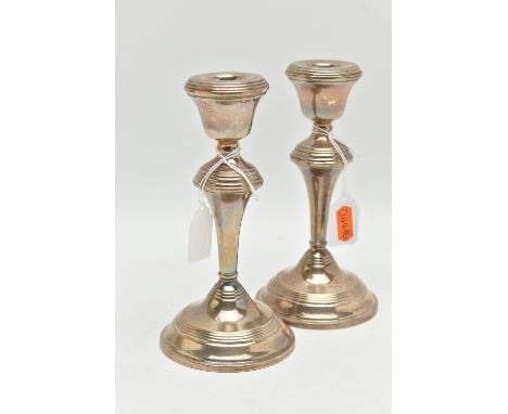 A PAIR OF SILVER CANDLE STICK HOLDERS, tapered polished form, on round weighted bases, approximate height 175mm, hallmarked '