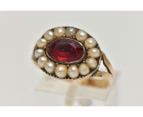 A LATE VICTORIAN PASTE AND SPLIT PEARL RING, designed as a central oval red paste within a split pearl surround, to the bifur