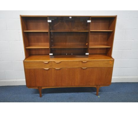 AN S FORM MID CENTURY TEAK HIGHBOARD, with an arrangement of shelving, flanking two smoked glass doors, enclosing another two