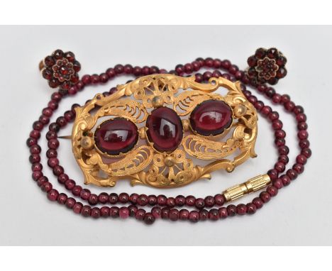 THREE PIECES OF JEWELLERY, to include a large base metal open work brooch set with three oval cut red paste cabochons, fitted