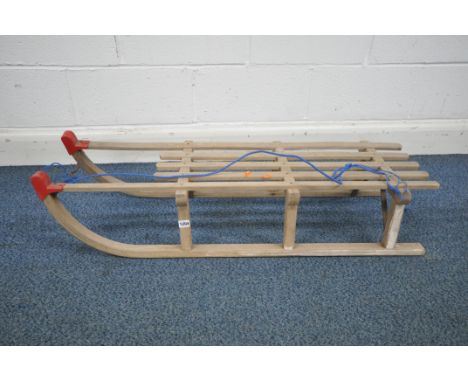 A VINTAGE GLOCO WOODEN SLED, with metal supports and red plastic caps, length 110cm (condition report: one plastic cap damage