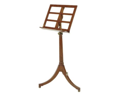 A William IV oak music stand, with an adjustable stem, on tripod supports and brass ball feet, 135.8cm high, 53.7cm wide.