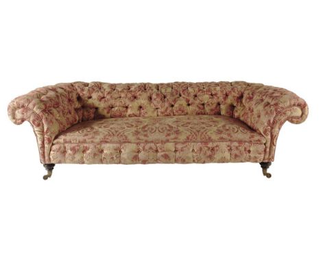 A late Victorian Chesterfield by Howard & Sons, with button upholstered damask fabric, with scroll arms on turned ebonized fr