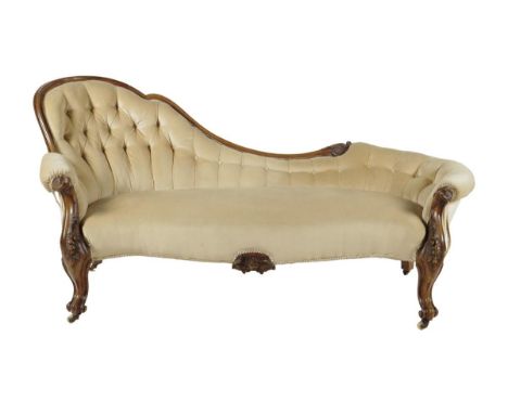 A Victorian walnut settee, the moulded frame carved with leaves and flowers, on cabriole legs and scroll feet and ceramic cas