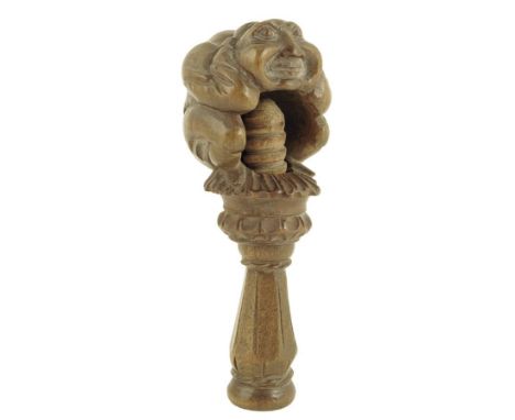 A 19th century Swiss carved walnut nutcracker in the form a crouching hunchback figure, 13.8cm high. Provenance: A private co